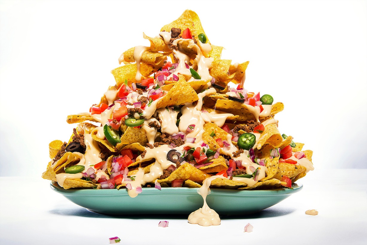 Food photography of a large plate of nachos with lots of toppings