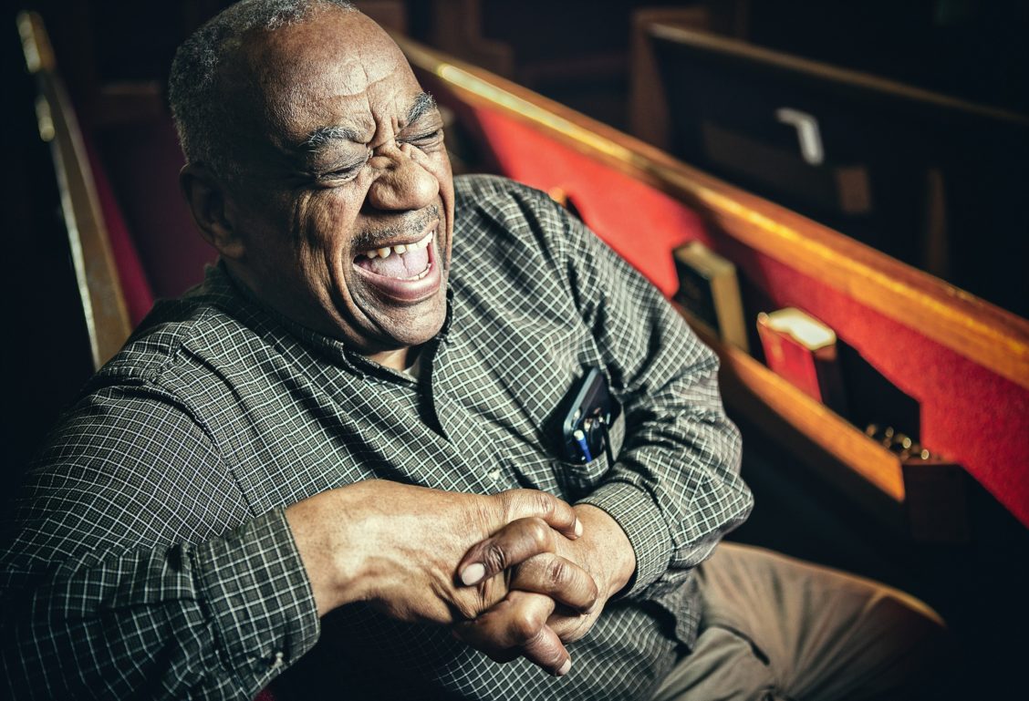 Lifestyle portrait of a man laughing in an empty theater