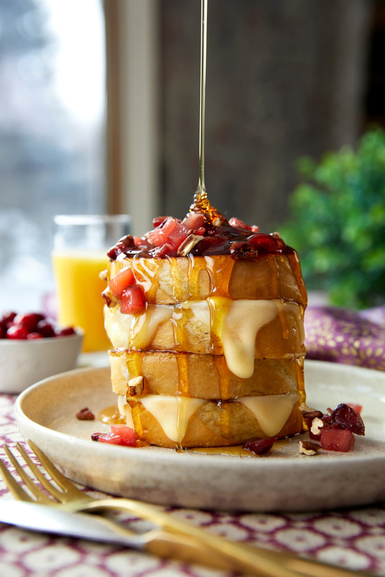 Food photography of a stack of french toast with syrup pouring on top