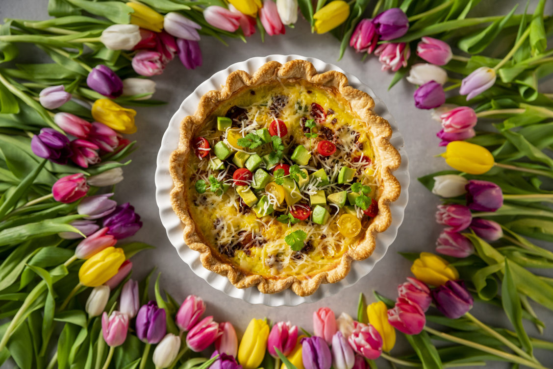 Quiche surrounded by tulips for a Mother's Day photograph