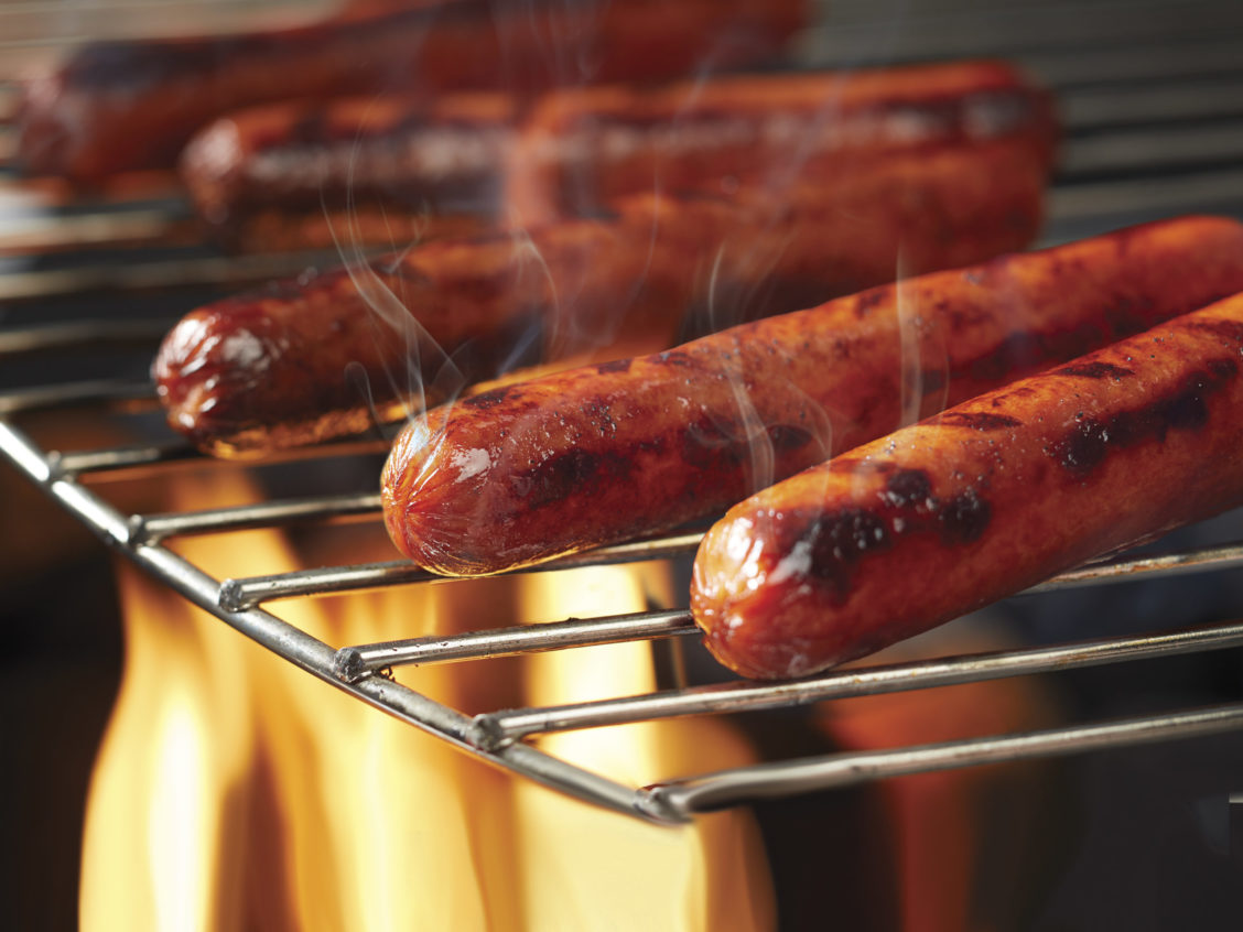 Food photography of hotdogs roasting and steam coming off of them