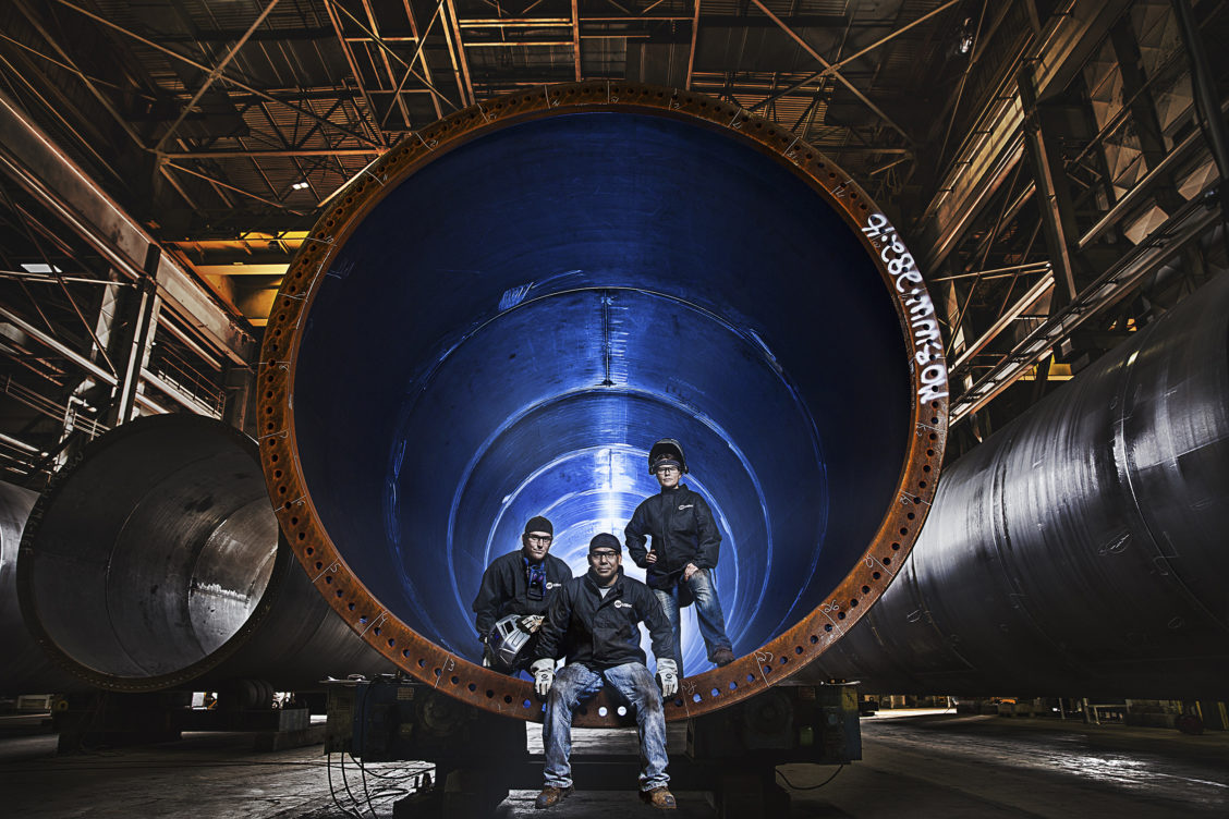 Group portrait of three employees in an industrial setting for Miller.