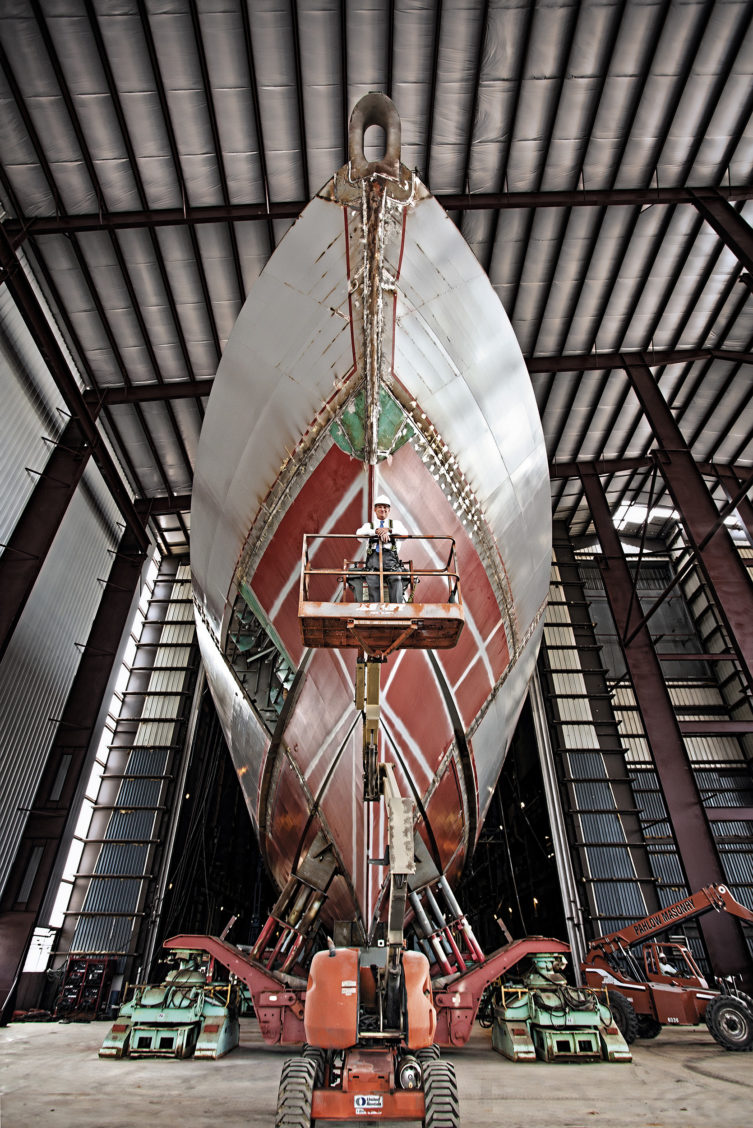 Photography of a large ship out of water in an industrial setting.