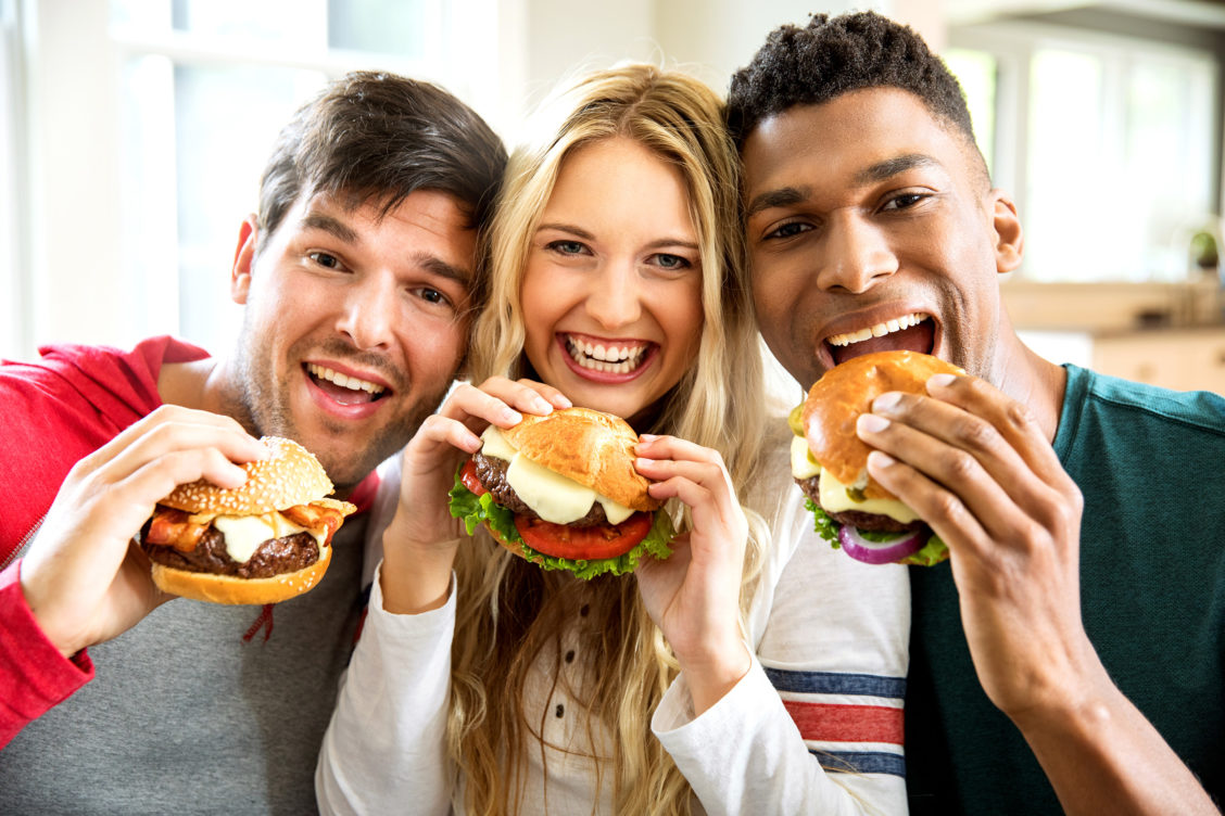 Three people holding burgers photographed for Cooper Cheese