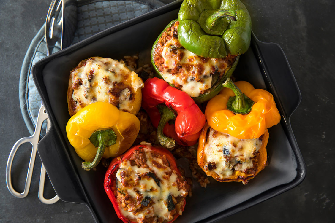 Styled food photography of four stuffed peppers