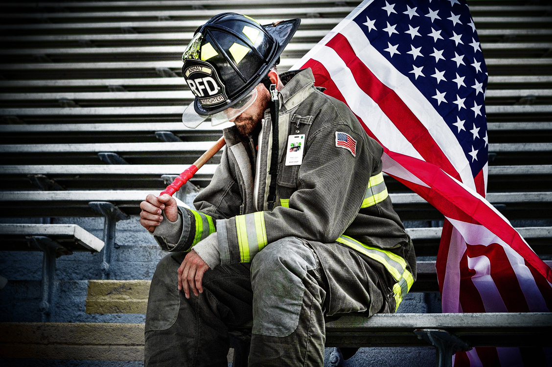 Patriotic image of a firefighter holding the United States flag after stair climb