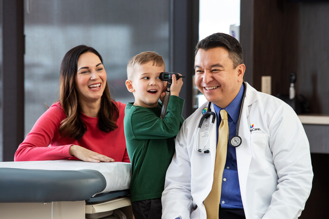 Lifestyle photography of a doctor interacting with a young patient using a stethoscope